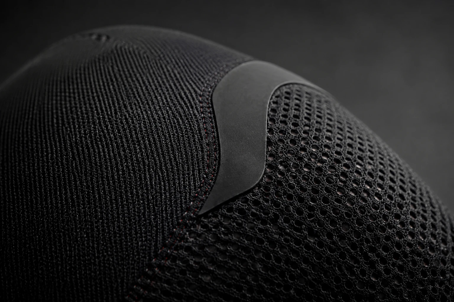 Photorealistic concept study of black anatomical knit, open mesh, and a low-profile cushioning zone